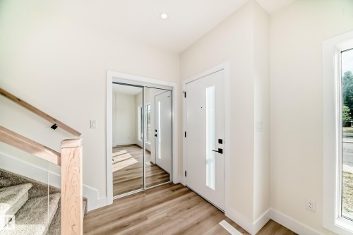 Entryway featuring hardwood floors, a white door with a vertical window, and a mirrored closet - 10718 149 Street Nw, Edmonton, AB - Indoor Photo Showing Other Room