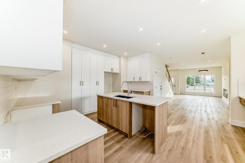 Modern kitchen with a light wood island and white countertops - 10718 149 Street Nw, Edmonton, AB - Indoor Photo Showing Kitchen With Double Sink