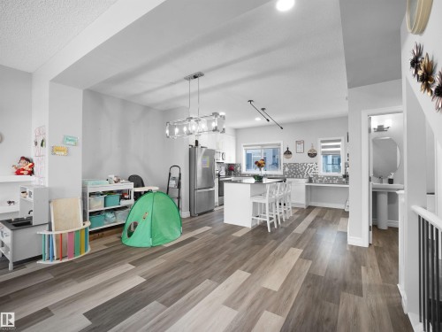 This property features an open concept kitchen and living area with wood-look flooring - 138 804 Welsh Drive, Edmonton, AB - Indoor