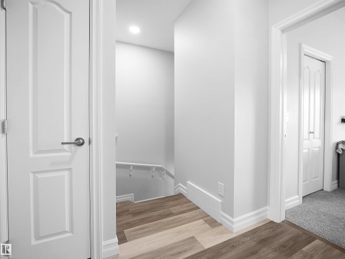 Interior hallway featuring light-toned flooring, white walls, and white doors with brushed nickel hardware - 138 804 Welsh Drive, Edmonton, AB - Indoor Photo Showing Other Room