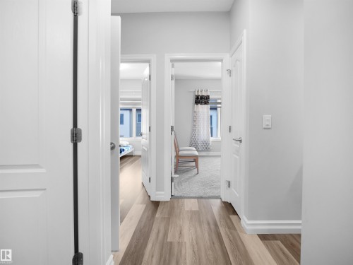 Hallway featuring light-colored walls, white trim, and wood-look flooring - 138 804 Welsh Drive, Edmonton, AB - Indoor Photo Showing Other Room