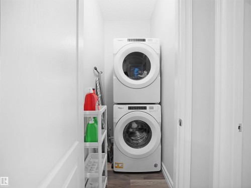 Dedicated laundry space featuring a stacked washer and dryer - 138 804 Welsh Drive, Edmonton, AB - Indoor Photo Showing Laundry Room