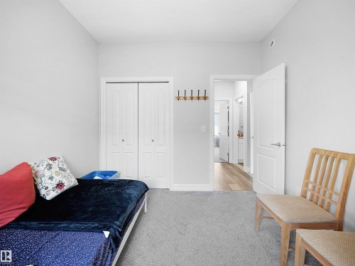 This room features light grey walls, grey carpeting, and white bi-fold closet doors - 138 804 Welsh Drive, Edmonton, AB - Indoor Photo Showing Bedroom