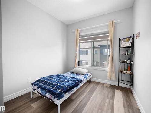 This room features light-colored walls and wood-look flooring - 138 804 Welsh Drive, Edmonton, AB - Indoor Photo Showing Bedroom