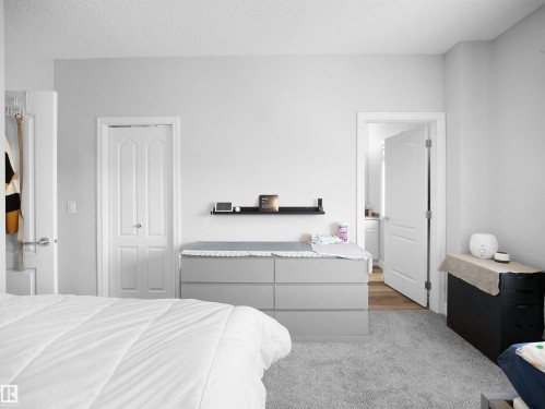 Bedroom featuring light gray walls, light gray carpet flooring, and white trim around the doors - 138 804 Welsh Drive, Edmonton, AB - Indoor Photo Showing Bedroom