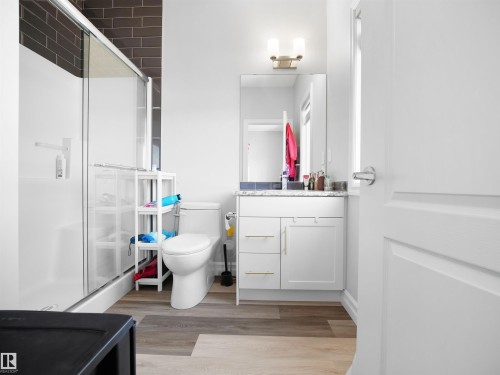 Bathroom featuring a shower with sliding glass doors, a white toilet, and a vanity with a white countertop - 138 804 Welsh Drive, Edmonton, AB - Indoor Photo Showing Bathroom