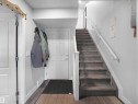 Entryway featuring light-toned walls, a white paneled door, and a staircase with carpeted treads and white railings - 138 804 Welsh Drive, Edmonton, AB  - Indoor Photo Showing Other Room 