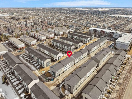 Aerial view of the property and surrounding neighborhood, featuring several rows of townhouses with dark gray roofs - 138 804 Welsh Drive, Edmonton, AB - Outdoor With View