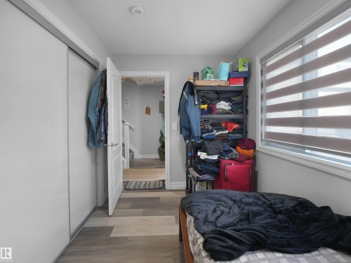 This room features light gray walls, a window with horizontal blinds, and a white sliding door closet - 138 804 Welsh Drive, Edmonton, AB - Indoor