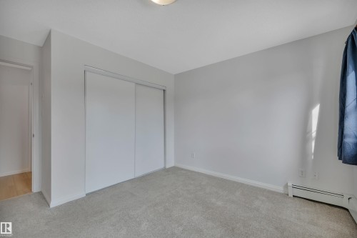 The room features light gray walls, a light gray carpet, and a white baseboard - 108 1204 156 Street, Edmonton, AB - Indoor Photo Showing Other Room