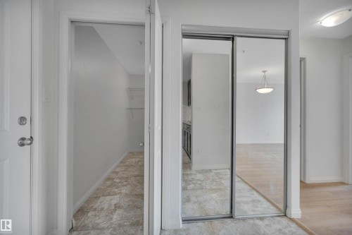 Entryway featuring a white door with a silver knob, mirrored closet doors, and tile flooring - 108 1204 156 Street, Edmonton, AB - Indoor
