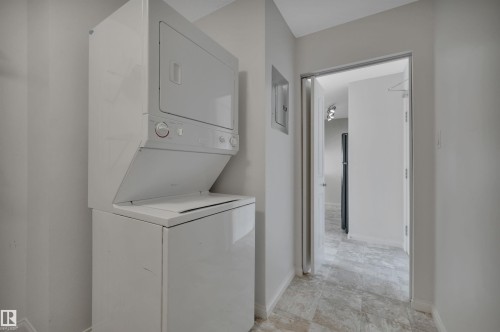 Dedicated laundry area featuring a white stacked washer and dryer, and tile flooring - 108 1204 156 Street, Edmonton, AB - Indoor Photo Showing Laundry Room