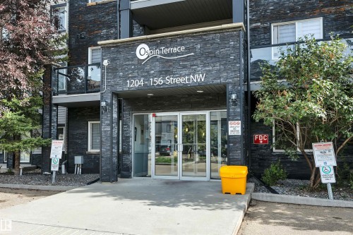 The property features a contemporary exterior with dark grey stacked stone cladding - 108 1204 156 Street, Edmonton, AB - Outdoor With Balcony