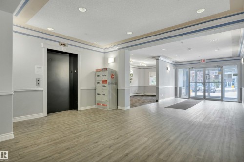 The property features a reception area with light-toned flooring, recessed lighting, and access to an elevator - 108 1204 156 Street, Edmonton, AB - Indoor Photo Showing Other Room