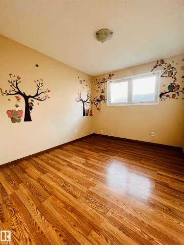 The room features wood-look flooring and a window providing natural light - 11459 51 Avenue, Edmonton, AB - Indoor Photo Showing Other Room