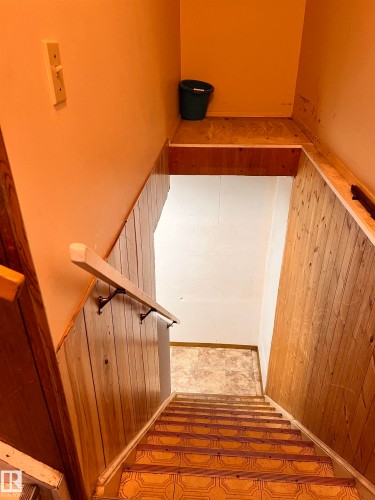 Stairway featuring wood paneling on the walls and patterned floor tiles on the treads - 11459 51 Avenue, Edmonton, AB - Indoor Photo Showing Other Room
