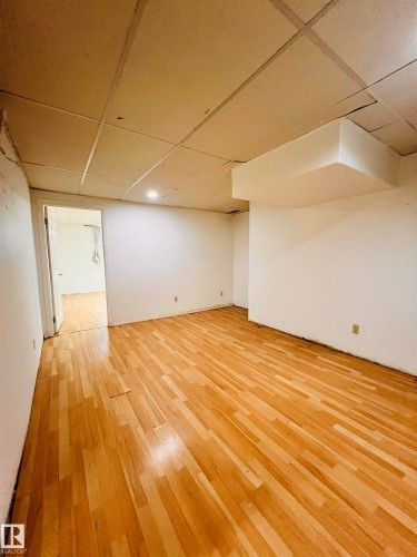 Spacious room featuring light-toned hardwood flooring and white walls - 11459 51 Avenue, Edmonton, AB - Indoor Photo Showing Other Room