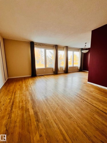 Living area featuring hardwood floors, a series of windows, and a ceiling light fixture - 11459 51 Avenue, Edmonton, AB - Indoor