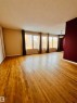 Living area featuring hardwood floors, a series of windows, and a ceiling light fixture - 11459 51 Avenue, Edmonton, AB  - Indoor 