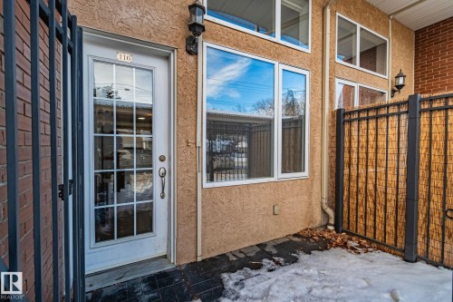 The property features a private entrance with a glass panel door and an exterior wall light - 116 11033 127 Street, Edmonton, AB - Outdoor With Exterior