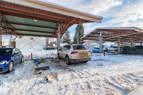 The property features covered parking structures with metal framing and corrugated roofing - 116 11033 127 Street, Edmonton, AB - Outdoor