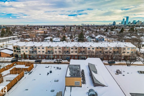 View of the surrounding neighbourhood featuring residential properties with snow-covered roofs and trees - 116 11033 127 Street, Edmonton, AB - Outdoor With View
