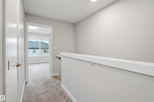 The property features light gray walls, white trim, and light brown carpeting throughout - 40 1729 Keene Crescent, Edmonton, AB - Indoor Photo Showing Other Room