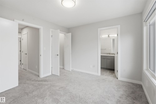 Well-lit room featuring light-colored carpet, a ceiling light fixture, and a window providing natural light - 40 1729 Keene Crescent, Edmonton, AB - Indoor
