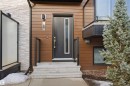 Exterior featuring a modern front door with a vertical glass insert, complemented by a bay window and dark wood siding - 40 1729 Keene Crescent, Edmonton, AB  - Outdoor With Exterior 