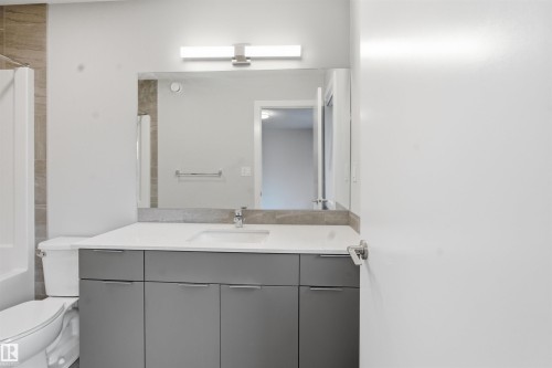 Bathroom featuring a vanity with a white countertop, an undermount sink, and grey cabinetry - 40 1729 Keene Crescent, Edmonton, AB - Indoor Photo Showing Bathroom