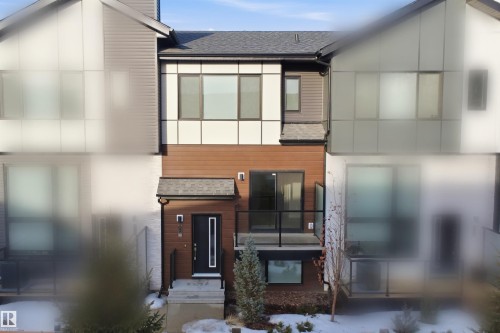 The property features modern architectural design with a dark roof and varied exterior finishes, including brown siding and lighter panels - 40 1729 Keene Crescent, Edmonton, AB - Outdoor