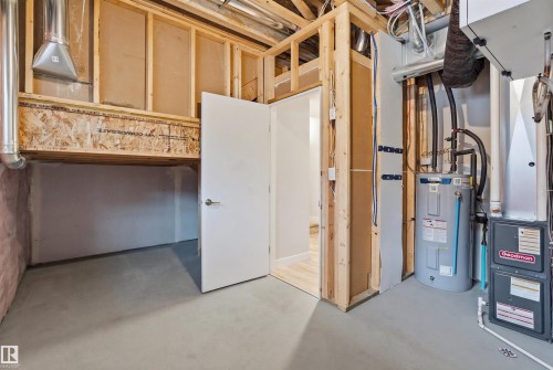The property features visible utilities and exposed wooden framing, along with a water heater and furnace - 40 1729 Keene Crescent, Edmonton, AB - Indoor Photo Showing Basement