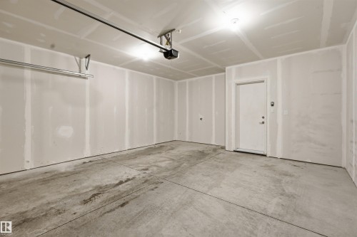 Spacious garage featuring a concrete floor, light-colored walls, and an overhead garage door opener - 40 1729 Keene Crescent, Edmonton, AB - Indoor Photo Showing Garage