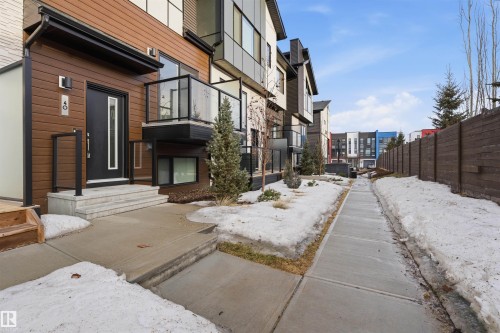 The property features a contemporary exterior with wood-style siding and a black front door with an opaque glass insert - 40 1729 Keene Crescent, Edmonton, AB - Outdoor