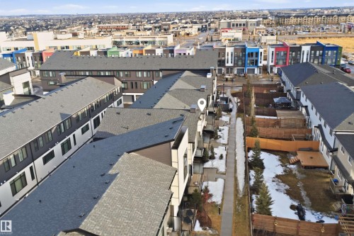 Aerial view showcasing the property's exterior, surrounded by other residential buildings and a distant urban landscape - 40 1729 Keene Crescent, Edmonton, AB - Outdoor With View