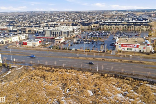 Aerial view showcasing a nearby commercial area with various retail establishments and a large parking lot - 40 1729 Keene Crescent, Edmonton, AB - Outdoor With View