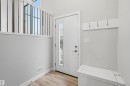 Entryway featuring light wood-style flooring, a white door with a window pane, a built-in bench, and a wall-mounted coat rack with hooks - 40 1729 Keene Crescent, Edmonton, AB  - Indoor Photo Showing Other Room 
