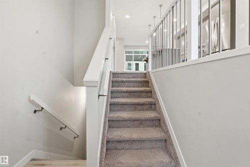 Carpeted staircase with white handrails and balusters - 40 1729 Keene Crescent, Edmonton, AB - Indoor Photo Showing Other Room