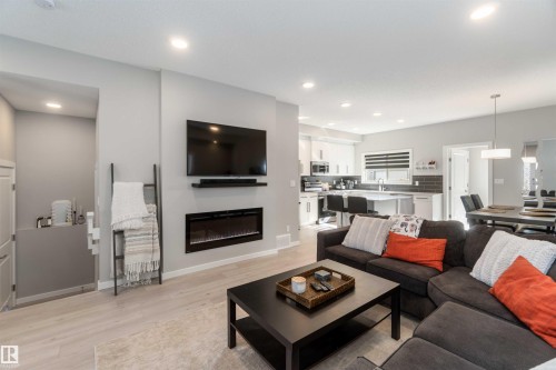 Bright and spacious living area featuring light-colored flooring, recessed lighting, and an electric fireplace - 29 Gambel Loop, Spruce Grove, AB - Indoor Photo Showing Living Room With Fireplace