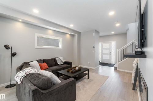 Open concept living area featuring light-toned flooring, recessed lighting, and a front entry door with decorative glass panels - 29 Gambel Loop, Spruce Grove, AB - Indoor Photo Showing Living Room