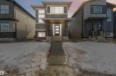 The property features a contemporary exterior with siding and stone accents, a covered front porch, and a front entry door with glass panels - 29 Gambel Loop, Spruce Grove, AB  - Outdoor With Facade 