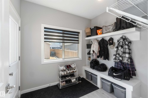 The mudroom features a built-in bench with storage, overhead shelving, and a window with blinds - 29 Gambel Loop, Spruce Grove, AB - Indoor Photo Showing Other Room