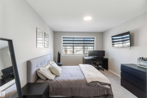 This room features neutral-toned walls, a window with horizontal blinds, and a ceiling light fixture - 29 Gambel Loop, Spruce Grove, AB - Indoor Photo Showing Bedroom