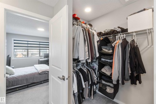 This room features soft gray carpeting and a window with horizontal blinds, offering views of the exterior - 29 Gambel Loop, Spruce Grove, AB - Indoor With Storage