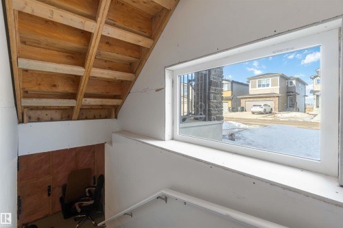 The interior features a window with a white frame, drywall on the walls, and exposed wooden ceiling beams - 29 Gambel Loop, Spruce Grove, AB - Indoor Photo Showing Other Room