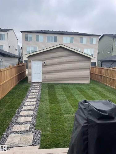 The property features a well-maintained lawn with a stepping stone path leading to an outbuilding - 29 Gambel Loop, Spruce Grove, AB - Outdoor