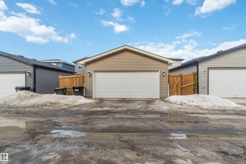 Detached garage featuring beige siding and a white overhead door - 29 Gambel Loop, Spruce Grove, AB - Outdoor