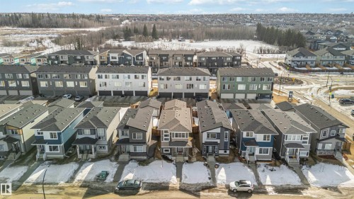 Aerial view showcasing a collection of modern detached homes and multi-story residences, set against a backdrop of natural landscaping - 29 Gambel Loop, Spruce Grove, AB - Outdoor