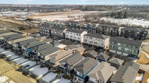 An aerial view showcases a residential development featuring a variety of properties with dark roofs and light-colored facades - 29 Gambel Loop, Spruce Grove, AB - Outdoor With View