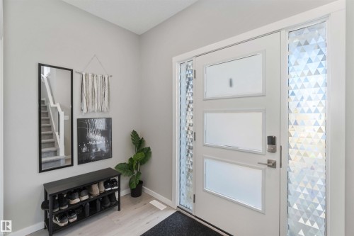 Inviting entrance featuring a modern white door with frosted glass panels and geometric patterned sidelights - 29 Gambel Loop, Spruce Grove, AB - Indoor Photo Showing Other Room